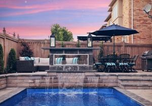 Poolside seating wall with waterfall and fire feature at sunset